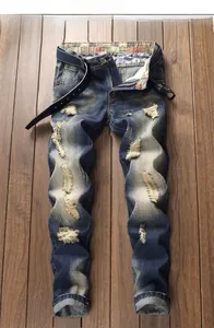 Close-up of distressed dark blue slim fit jeans with heavy washing and ripped details