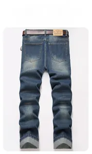 Detail of vintage blue jeans showing leather patch and belt on the back waistband