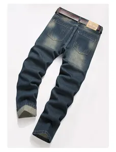 Close-up of vintage blue denim jeans back pocket with brown leather belt and brand label