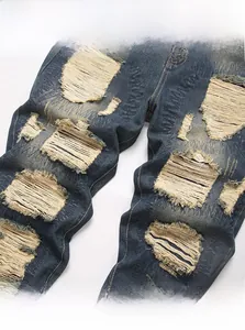 Detailed close-up of distressed denim fabric with ripped patterns and soft woven texture