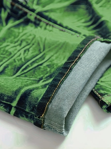 Gros plan du denim stretch vert avec coutures contrastées et texture délavée à l'acide