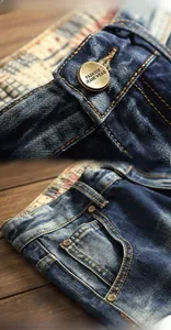Detail of vintage copper button with embossed text and worn denim fabric texture
