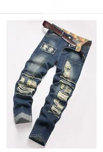 Detail of heavy wash distressed jeans with denim patchwork and brown leather belt