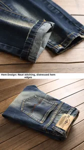 Detail of dark blue vintage jeans featuring distressed hem and brown leather waist patch