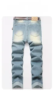 Detail view of denim jeans featuring back pockets and a leather waist patch with a brown belt