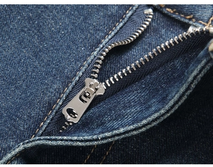 Detailed close-up of premium metal zipper and yellow stitching on dark blue denim jeans