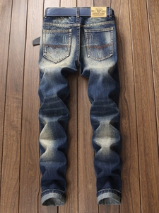 Men's vintage slim fit straight jeans in washed deep blue with belt on wooden floor