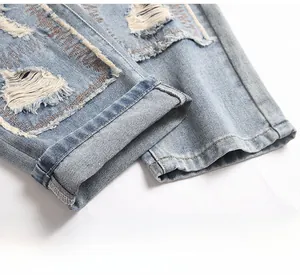 Detailed close-up of distressed denim hem and ripped texture on light blue vintage jeans