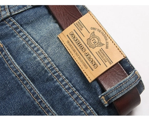 Close-up of vintage blue denim jeans back waist with leather belt and retro brand patch