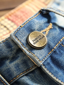 Jean droit bleu clair délavé avec détails usés et bouton métallique en bronze à la taille