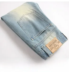 Detail of light blue denim jeans showing the back pocket and vintage brown leather brand patch