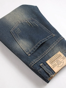 Vintage blue distressed denim jeans for men with washed finish and leather logo patch