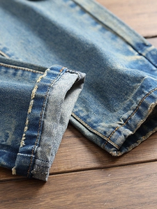 Jean droit bleu clair délavé style vintage avec ourlets retroussés et finitions usées