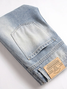 Men's vintage light blue distressed denim jeans with retro waist label and washed texture