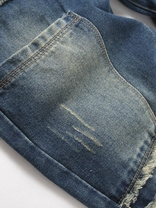 Vintage distressed blue jeans with retro wash patterns and frayed edge details