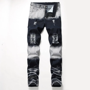 Vista macro di jeans in denim con lavaggio sfumato e dettagli strappati sul ginocchio