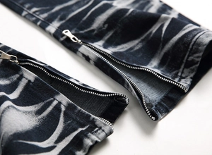 Dettaglio della cerniera in metallo argentato sui jeans tie-dye da uomo lavati