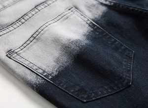 Dettaglio del tessuto denim lavato sfumato blu e grigio con tasca posteriore cucita
