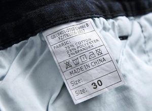 Dettaglio etichetta composizione materiale per jeans elasticizzati strappati da uomo