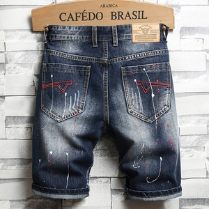 Men's vintage dark blue ripped denim shorts with paint splatters and embroidery detail