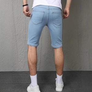 Detail view of the back pockets and slim fit design of men's light blue denim shorts