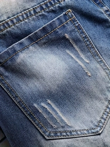 Men's loose straight denim shorts with distressed ripped detail and blue washed finish
