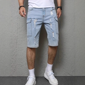 Dettaglio dei pantaloncini cargo in denim blu chiaro con strappi e tasche laterali