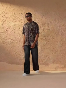 Street style leopard print t-shirt and black straight trousers on a textured background