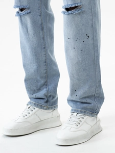 Hellblaue Washed-Jeans mit Rissen an den Knien und künstlerischen Farbspritzer-Details