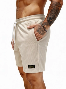 Men's beige corduroy shorts featuring drawstring waist and vintage style side patch