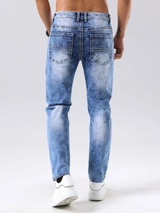 Détail d'un jean slim homme délavé bleu clair avec broderie de vague sur la poche arrière