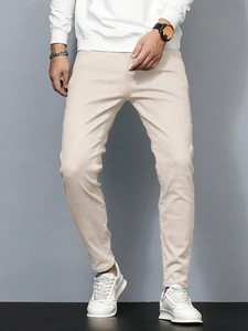 Pantalon de ville slim beige pour homme assorti à des baskets pour un look décontracté