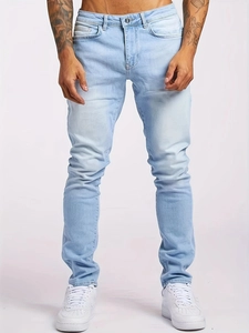 Slim fit light blue washed denim jeans for men paired with white sneakers in a clean studio shot