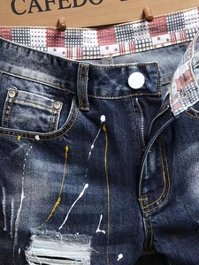 Short en jean bleu délavé avec taches de peinture, style vintage et doublure contrastée