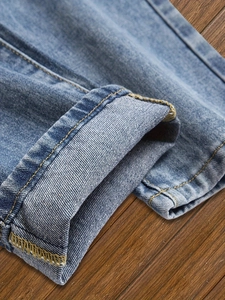 Jean en denim bleu délavé avec détails d'ourlets repliés de qualité et coutures contrastées