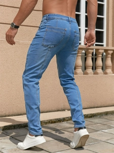 Schmal geschnittene Herrenjeans in Hellblau mit Gesäßtaschen in einer Outdoor-Lifestyle-Ansicht