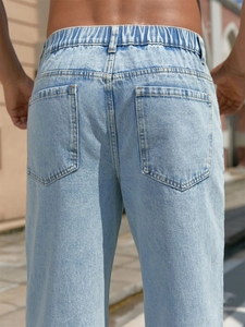 Close-up of light blue baggy jeans back view with elastic waist and dual pockets