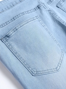 Detailed back pocket view of men's distressed light blue slim fit stretch denim jeans