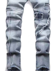 Slim fit light blue distressed jeans with ripped patches and raw hem details