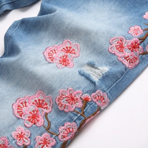 Jean évasé bleu clair pour hommes avec déchirures et broderies de fleurs de cerisier