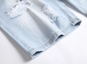 Détail macro du denim bleu clair avec déchirures usées et ourlet à bords effilochés