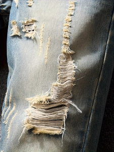 Men's retro light blue straight jeans with heavy distressed ripped details on knees
