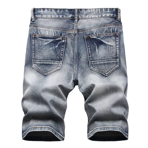 Detail view of denim shorts back featuring washed light blue fabric and distressed pockets