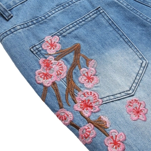 Jean évasé bleu clair pour homme avec broderie détaillée de cerisier sur la poche arrière