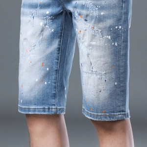 Men's slim distressed denim shorts with paint splatter and ripped details in light blue
