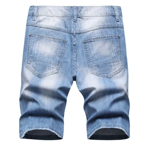 Détail des poches arrière d'un short en jean délavé bleu clair avec bords effilochés