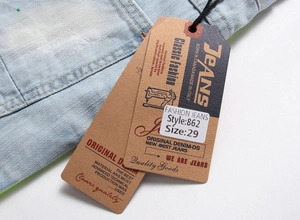 Détail des étiquettes en papier du short en jean montrant la taille 29 et la couture