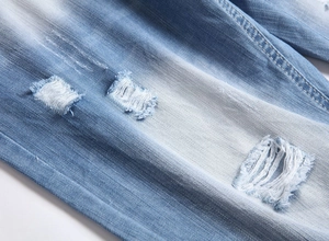 Vue macro détaillée d'un short en jean bleu clair avec des trous déchirés et bords effilochés