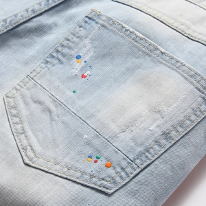 Jean bleu clair pour homme avec des éclaboussures de peinture colorées et des détails usés mode
