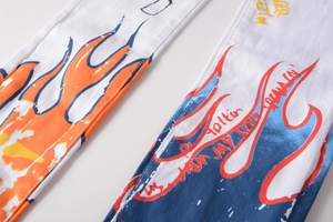 Detail of white denim jeans with orange flame and blue graffiti art print for men